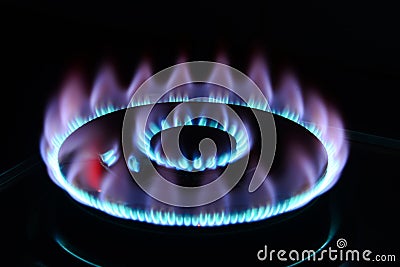 The blue flame of a cooker burner in the dark Stock Photo