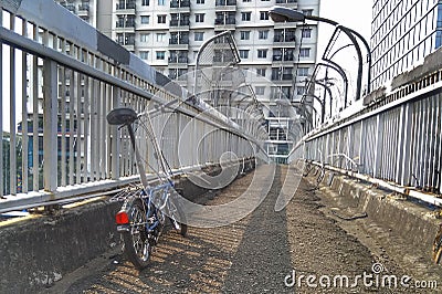 Blue folding bike parked on a pedestrian bridge Stock Photo