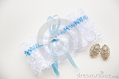 Blue Garter of the bride and her beautiful wedding jewelry Stock Photo