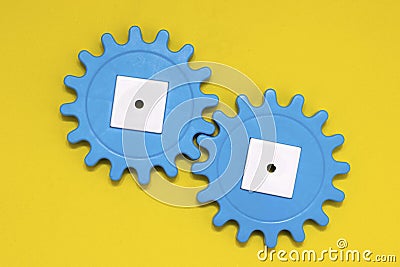 Blue gears on a yellow background, copy space. Interaction concept. The photo Stock Photo