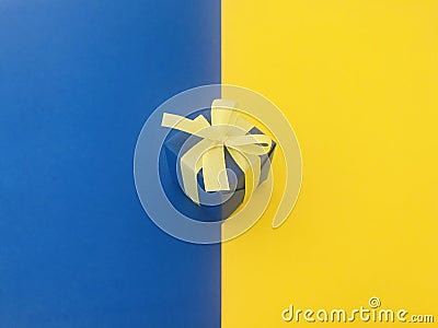 Blue gift box on half yellow and blue background. Stock Photo