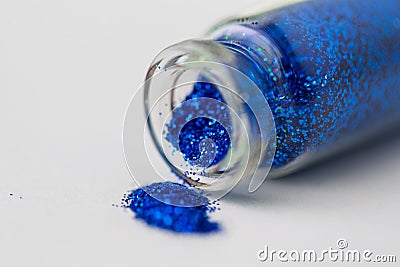 Blue glitters poured from small glass bottle Stock Photo