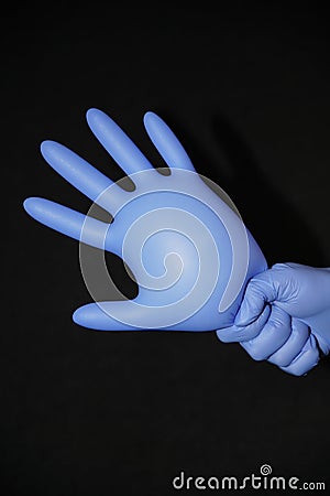 Blue gloved hand, holding a filled syringe, squirting down Stock Photo