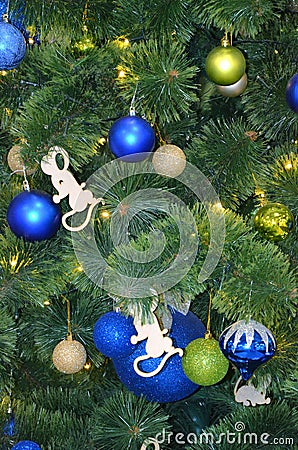 Blue and green balls on a faux christmas tree close and a glowing garland up Stock Photo