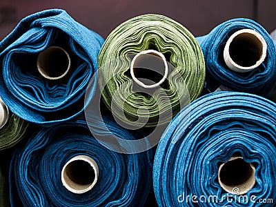 Blue and green rolls of knitted fabric. Woven factory or warehouse Stock Photo