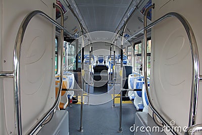 Blue and grey seats for passengers in saloon of empty city bus Editorial Stock Photo
