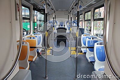 Blue and grey seats for passengers in saloon of empty city bus Stock Photo