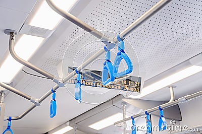 Blue hanging handholds for standing passengers in a modern train Stock Photo