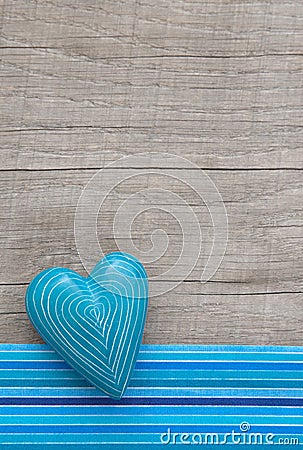 Blue heart with symmetric carved lines on grey wooden background Stock Photo