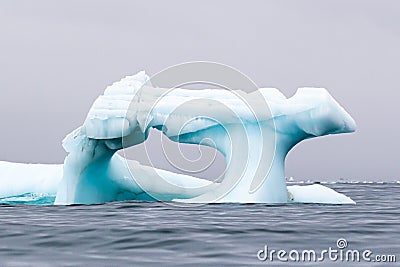 A blue ice berg floating in the Arctic north of Svalbard in the Arctic Stock Photo