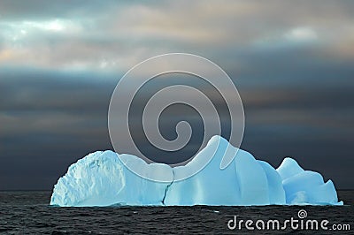 Blue iceberg with dark sky Stock Photo