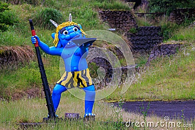 Blue Japanese oni demon in front of dry stone riverbed Editorial Stock Photo