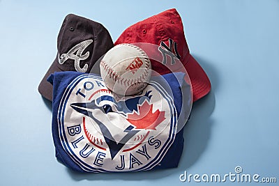 Blue Jays shirt, Braves and Yankees caps against a blue background Editorial Stock Photo