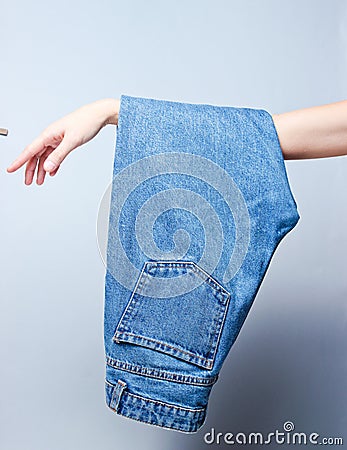 Blue jeans hanging on a female hand Stock Photo