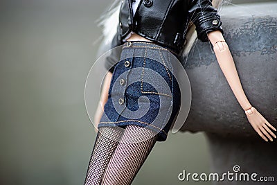 blue jeans skirt and black leather jacket on blond manequin doll in outdoor Stock Photo