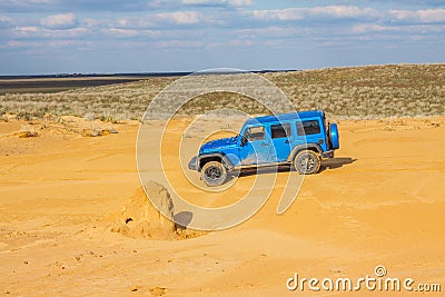 Blue Jeep Wrangler Rubicon Unlimited at desert sand dunes Editorial Stock Photo