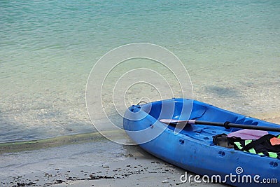 Blue Kayak on the tropical white sand beach with sea waves. Scenic relaxing scenery Stock Photo