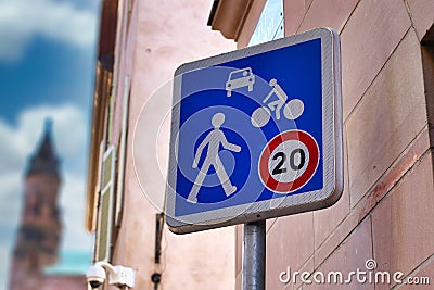 Blue 20km/h Home Zone speed limit sign showing car, bicycle and pedestrian in French street Stock Photo