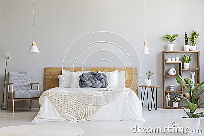 Blue knot pillow on wooden bed in modern bedroom interior with p Stock Photo