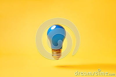 Blue lightbulb levitate on yellow background. Idea and inspiration concept Stock Photo