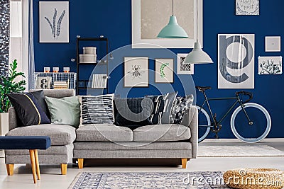 Blue living room with inspiring poster on the wall and grey sofa Stock Photo