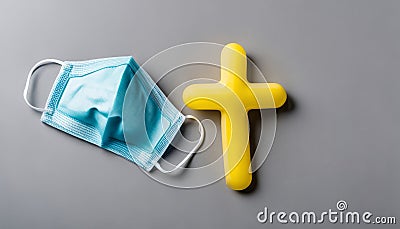 A blue mask and yellow cross on a table Stock Photo