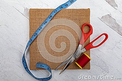 Blue measuring tape red tread spool and scissors craft sewing supplies Stock Photo