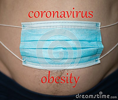Blue medical mask on man`s stomach, man gaining weight during coronavirus crisis pandemic. Stock Photo