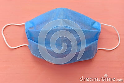 Blue medical mask with white elastic bands for the ears. Face mask on a pink background Stock Photo