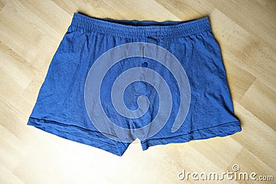 Blue men`s underpants lying on the floor, knitted underwear, concept of comfortable clothing, scandal of Russian special services Stock Photo