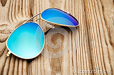 Blue mirrored sunglasses on the wooden background close up Stock Photo