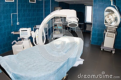 Modern operating room with X-ray medical scan, operating table, special lamp and medical devices. Stock Photo