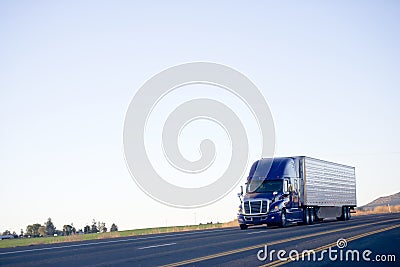 Blue modern semi truck reefer trailer carry cargo on highway Stock Photo