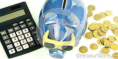 Blue money box between coins pile and outdated calculator Stock Photo