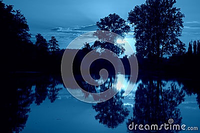 Blue mood sunset over bayou with water reflection Stock Photo