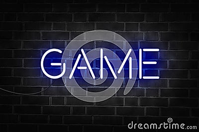 Blue neon sign of the word GAME on dark brick wall Stock Photo