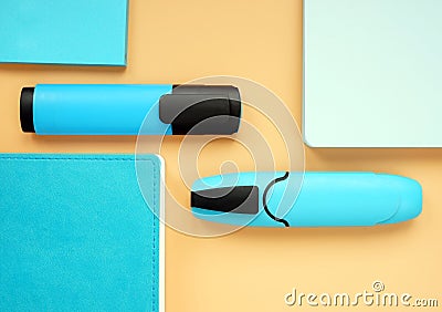 Blue notepads and markers on an orange surface. Top view of office supply Stock Photo