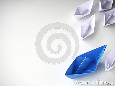 Blue paper boat leading among white ships Stock Photo