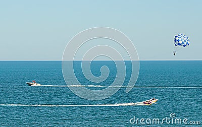 Blue parasail wing pulled by a boat in the sea water, Parasailing also known as parascending or parakiting Stock Photo