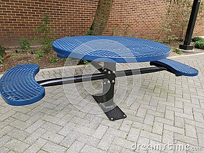 Blue park bench by brick wall Stock Photo