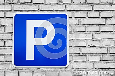 Blue parking sign on black and white bricks Stock Photo