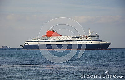 Blue passenger ship at sea in the clouds Stock Photo