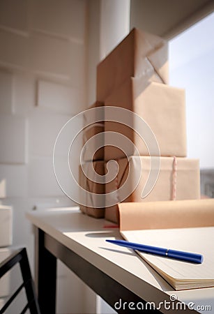 Blue pen on the notebook with wrapped parcel on white desk Stock Photo