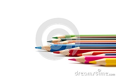 Blue pencil stands out from a number of other colored pencils lying on an isolated white background Stock Photo