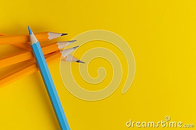 A blue pencil at the top of a group of yellow pencils Stock Photo