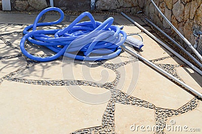 Blue plastic long large corrugated hose for cleaning the pool wash and watering the plants Stock Photo