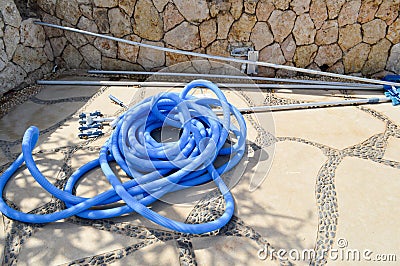 Blue plastic long large corrugated hose for cleaning the pool wash and watering the plants Stock Photo