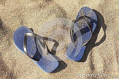 Blue plastic thongs in the sand Stock Photo