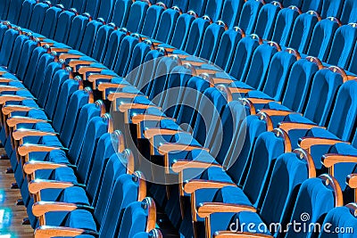 Blue plush chairs with wooden armrests in the auditorium. Empty auditorium in the theater Stock Photo