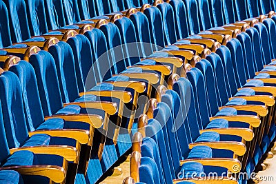 Blue plush chairs with wooden armrests in the auditorium. Empty auditorium in the theater Stock Photo